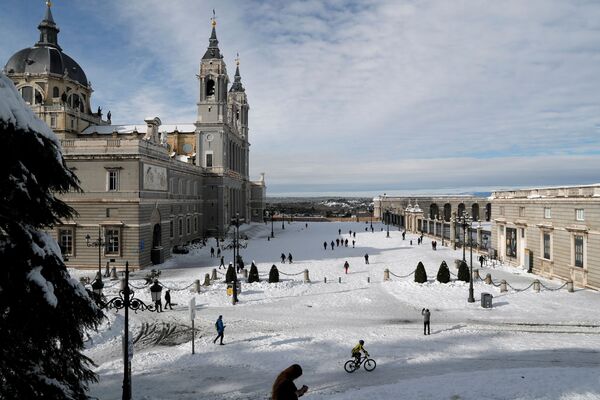 Люди гуляют по снегу возле собора Ла Альмудена в Мадриде - Sputnik Беларусь