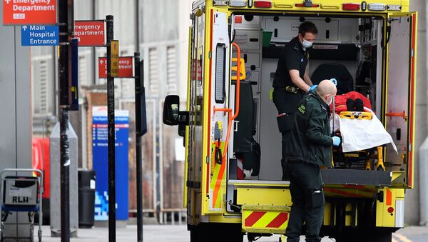 Медицинские работники вывозят пациента из машины скорой помощи в Лондоне - Sputnik Беларусь