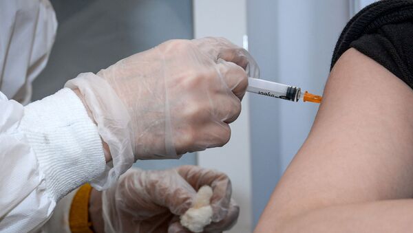 Медицинский сотрудник вводит женщине вакцину от COVID-19 - Sputnik Беларусь