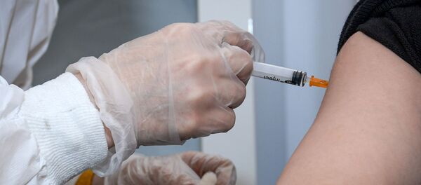 Медицинский сотрудник вводит женщине вакцину от COVID-19 - Sputnik Беларусь