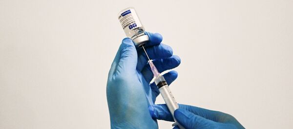 Медыцынскі супрацоўнік трымае ў руках вакцыну Спутнік V Медыцынскі супрацоўнік трымае ў руках вакцыну Спутнік V - Sputnik Беларусь