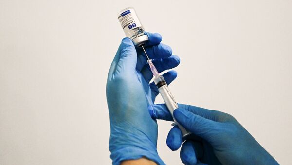 Медицинский сотрудник держит в руках вакцину Спутник-V - Sputnik Беларусь