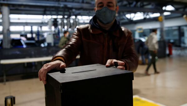 Мужчина в защитной маске ставит ящик на избирательном участке во время подготовки к президентским выборам в Португалии на фоне пандемии коронавируса (COVID-19) в Лиссабоне - Sputnik Беларусь