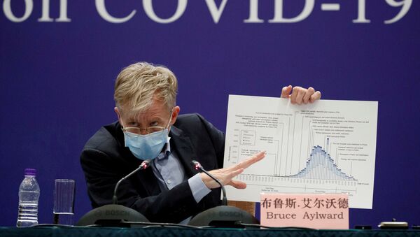 Представитель ВОЗ Брюс Эйлворд держит диаграмму во время пресс-конференции - Sputnik Беларусь