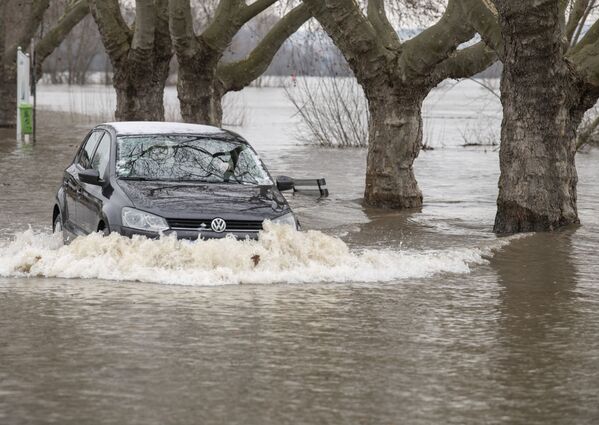 Автомобиль на дороге, затопленной паводком, в Рюдесхайм-на-Рейне в земле Гессен - Sputnik Беларусь