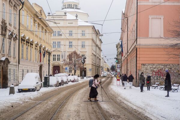 Женщина на лыжах переходит дорогу в Праге - Sputnik Беларусь