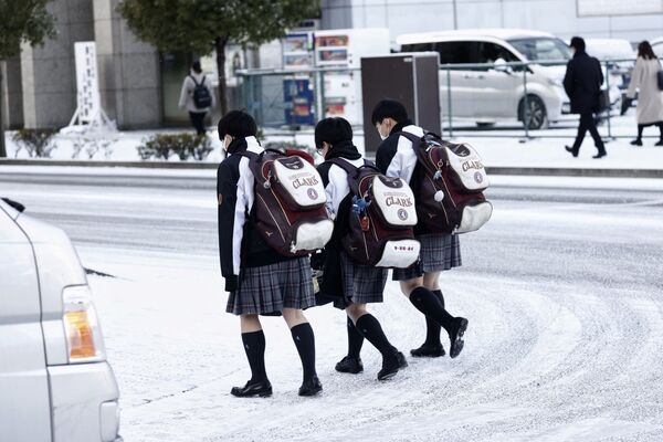 Школьницы идут по заснеженной улице в Сендае, префектура Мияги - Sputnik Беларусь