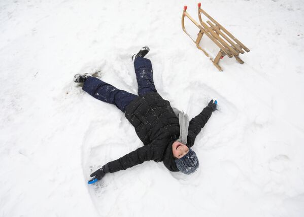 Ребенок делает ангела на снегу после сильного снегопада в Амстердаме - Sputnik Беларусь