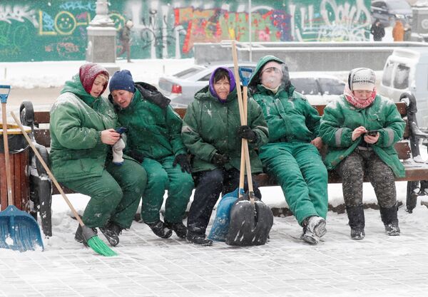 Коммунальные работники, убирающие снег, во время перерыва в центре Киева - Sputnik Беларусь
