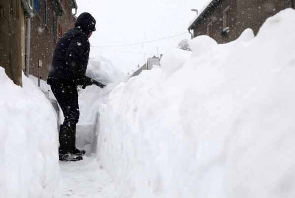 Мужчина расчищает дорожку во время сильного снегопада в Острамондре, к западу от Лейпцига, Германия - Sputnik Беларусь