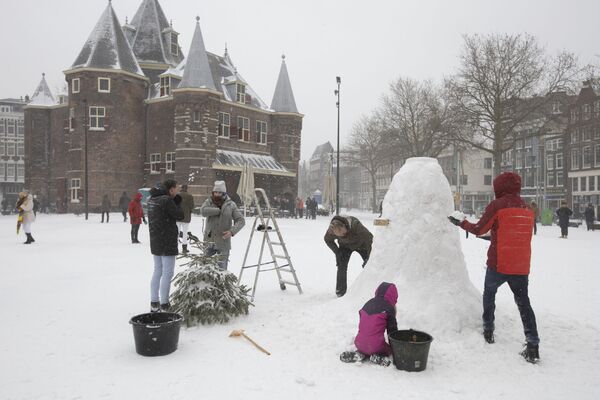 Люди лепят снеговика в центре Амстердама - Sputnik Беларусь
