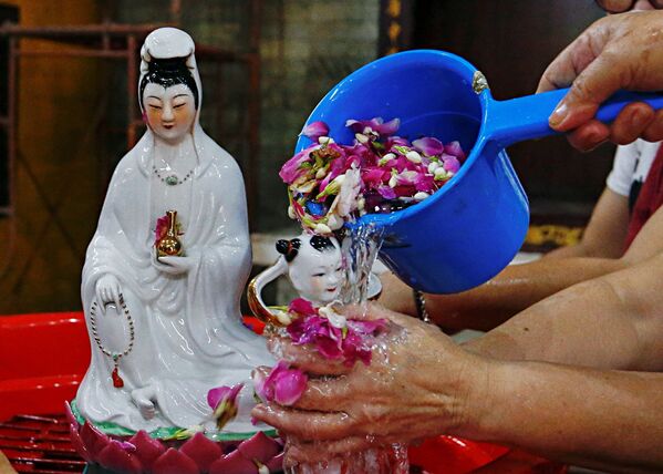 Женщины омывают религиозную статуэтку перед наступлением Праздника Весны в храме в Джакарте, Индонезия - Sputnik Беларусь