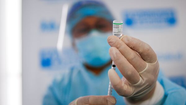 Медицинский работник набирает в шприц вакцину от коронавируса - Sputnik Беларусь