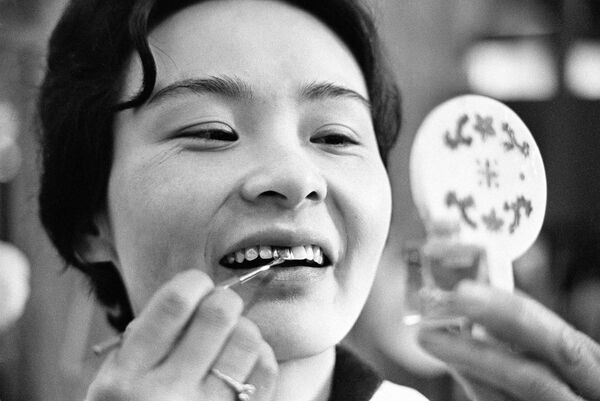 Женские зубы в Японии в разное время выделялись цветом. В древности женщины покрывали зубы черным лаком в знак красоты. Позже это стало обычаем только для замужних женщин. Тошико Фукаям наносит цветное покрытие на свои зубы, 7 апреля 1966 года, Япония. - Sputnik Беларусь