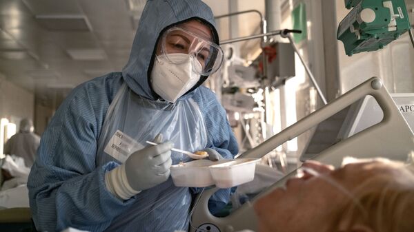 Медсестра кормит пациента в отделении реанимации и интенсивной терапии в больнице в Москве - Sputnik Беларусь