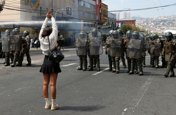 Девушка перед отрядом полиции на митинге во время празднования Женского дня в Вальпараисо, Чили - Sputnik Беларусь