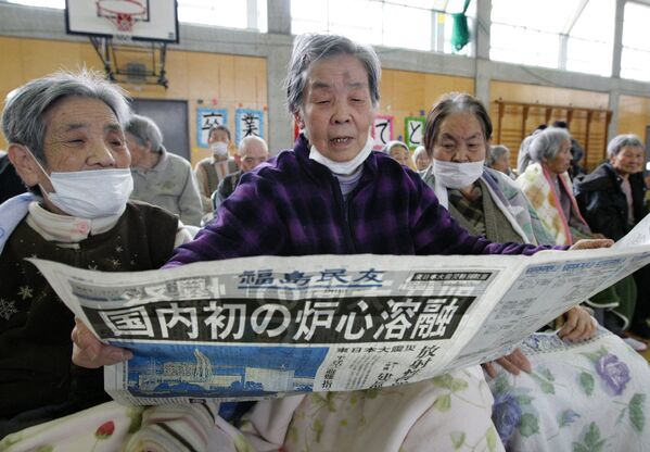Пожилые люди, эвакуированные из района возле АЭС Фукусима, читают газету с сообщениями о взрыве на станции - Sputnik Беларусь