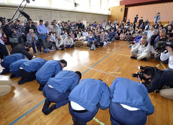 Президент компании Tokyo Electric Power Co. (TEPCO) Масатака Симидзу и другие сотрудники извиняются и кланяются перед эвакуированными из города Намиэ - Sputnik Беларусь