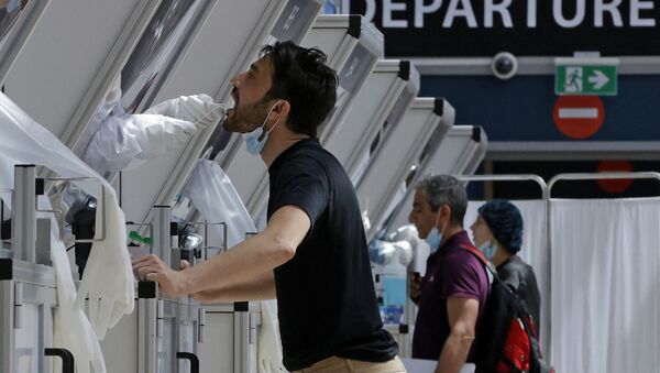 Медик берет мазок у путешественника в будке для экспресс-тестирования COVID-19 в израильском аэропорту Бен-Гурион - Sputnik Беларусь
