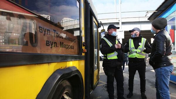 Сотрудники полиции проверяют наличие у пассажиров спецпропусков для проезда на общественном транспорте на одной из остановок в Киеве - Sputnik Беларусь