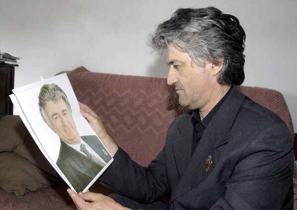 Петар Чикич, 47-летний боснийский серб, держит фотографию военного преступника Радована Караджича, на которого он очень похож.  - Sputnik Беларусь