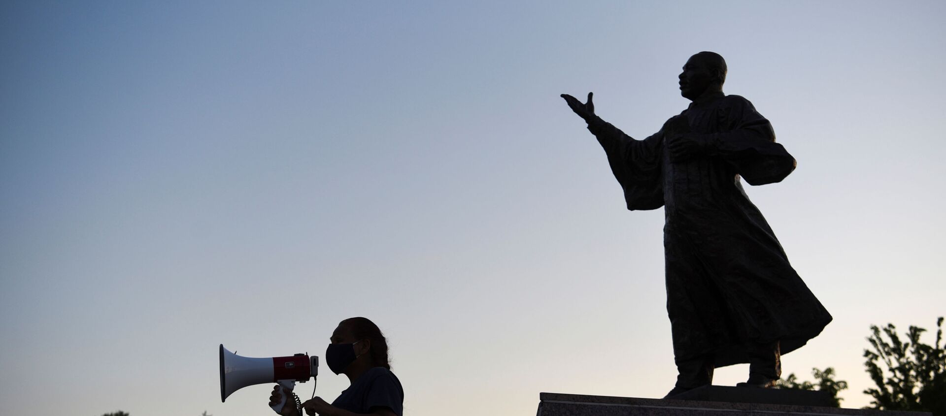 Женщина обращается к толпе перед статуей, посвященной Мартину Лютеру Кингу-младшему - Sputnik Беларусь, 1920, 27.04.2021