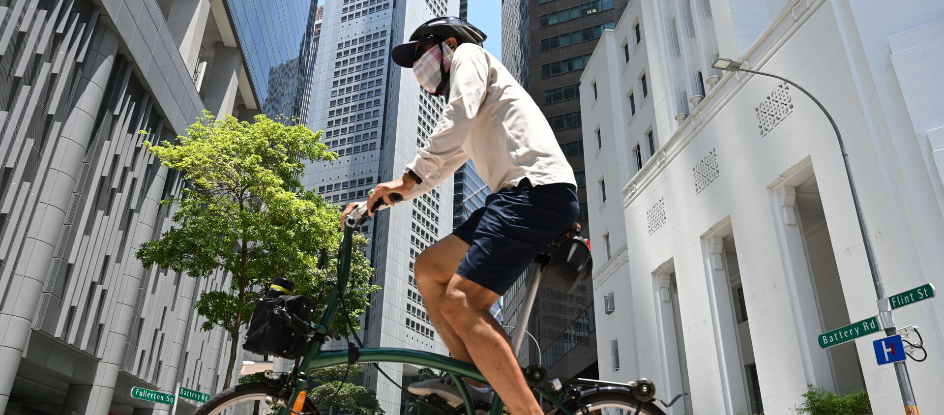 Мужчина едет на велосипеде по улице в Сингапуре  - Sputnik Беларусь, 1920, 27.04.2021