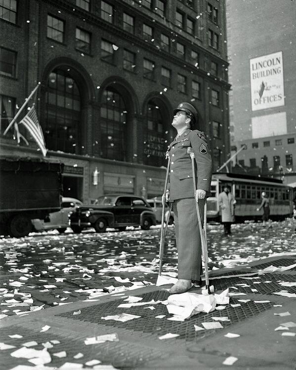 Штаб-сержант Артур Мур из Буффало, раненный в Бельгии, стоит на 42-й улице возле Центрального вокзала Нью-Йорка 7 мая 1945 года - в день, когда жители Нью-Йорка праздновали победу над нацистской Германией. - Sputnik Беларусь