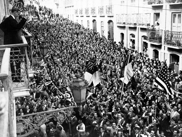 Люди выходят на улицу возле посольств США и Великобритании в Лиссабоне, Португалия, в День Победы, 8 мая 1945 года. Ликующие толпы праздновали два дня и две ночи.  - Sputnik Беларусь