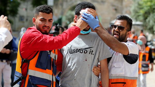 Медики оказывают помощь раненому палестинцу во время столкновений с израильской полицией  - Sputnik Беларусь