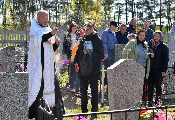 Протоирей Валерий проводил поминальную службу прямо на кладбище, а затем целый день читал молитвы у могил. - Sputnik Беларусь