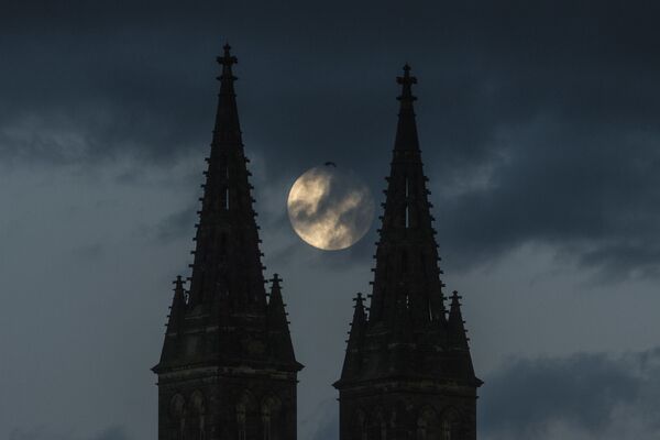 Полная луна поднимается за базиликой Святых Петра и Павла, частью Вышеградского замка в Праге. - Sputnik Беларусь