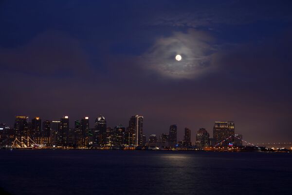 Полная луна поднимается сквозь низкие облака над городом Сан-Диего, Калифорния. - Sputnik Беларусь