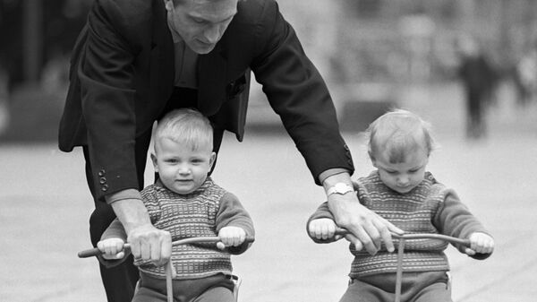 Отец учит детей-близнецов кататься на трехколесных велосипедах, 1968 год - Sputnik Беларусь