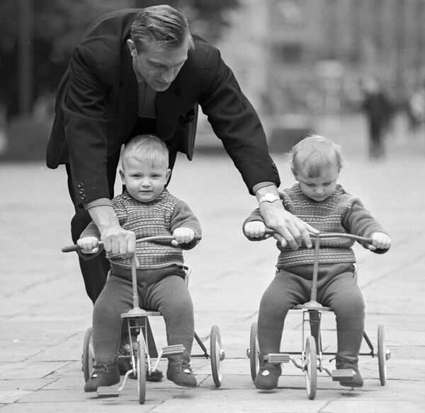 Отец учит детей-близнецов кататься на трехколесных велосипедах, 1968 год. - Sputnik Беларусь