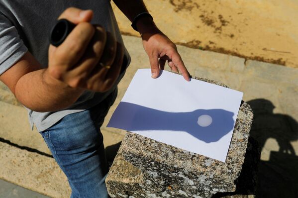 С помощью монокуляра житель Ронды на юге Испании отразил частичное солнечное затмение на бумаге. - Sputnik Беларусь