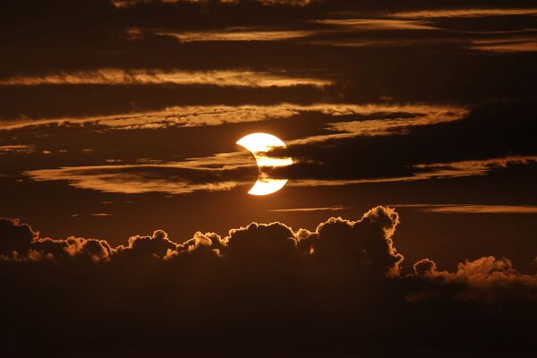 Частичное солнечное затмение за облаками в Арбутусе, американский штат Мэриленд.  - Sputnik Беларусь