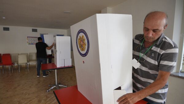 Член участковой избирательной комиссии устанавливает кабины для голосования на избирательном участке в Ереване - Sputnik Беларусь