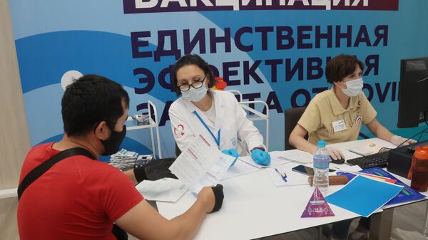 Медицинский сотрудник информирует посетителя, проходящего вакцинацию от COVID-19 - Sputnik Беларусь