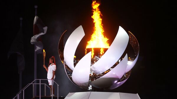 Наоми Осака из Японии держит олимпийский факел после зажжения олимпийского котла на церемонии открытия  - Sputnik Беларусь
