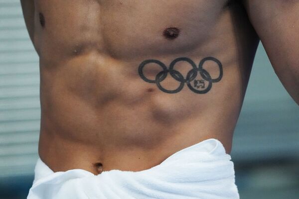 Вот такую лаконичную олимпийскую татуировку на теле пловца запечатлел фотограф в Токио. - Sputnik Беларусь