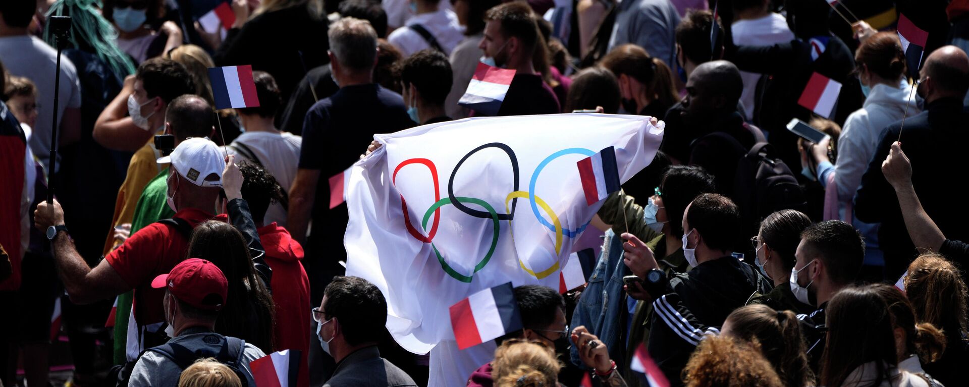 Болельщики несут флаг в фан-зоне Олимпийских игр в садах Трокадеро перед Эйфелевой башней в Париже, воскресенье, 8 августа 2021 года - Sputnik Беларусь, 1920, 08.08.2021