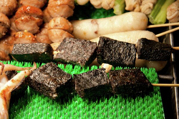 Третье место у тайваньских пирожков из свиной крови - их продают как эскимо, на палочке. Готовят с добавлением риса, кинзы и арахисовой муки. Но по сути  — привычная для Европы кровяная колбаса. - Sputnik Беларусь