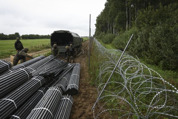 Польские солдаты выгружают материалы для строительства забора из колючей проволоки. - Sputnik Беларусь