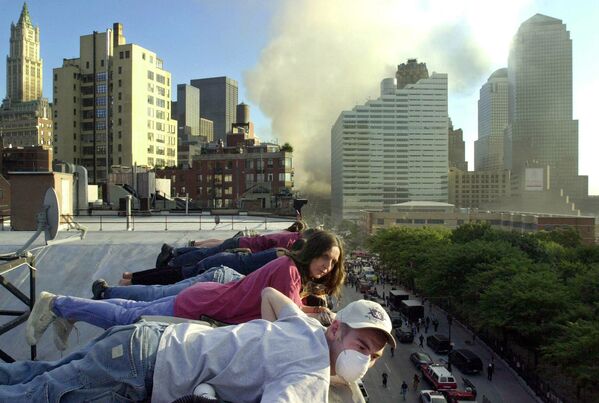 Жители наблюдают с крыши здания на Гринвич-стрит в Нью-Йорке за спасательными работами внизу. - Sputnik Беларусь