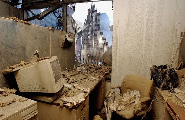 Из офиса, заполненного пылью и обломками, виден обрушившийся небосреб башен-близнецов.  - Sputnik Беларусь