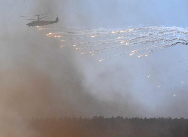 Ударный вертолет прикрывая действия союзников отстреливает тепловые ловушки. - Sputnik Беларусь