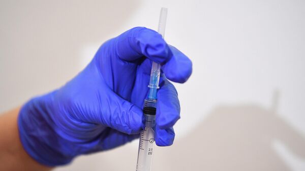 Медик набирает препарат в шприц во время вакцинации  - Sputnik Беларусь
