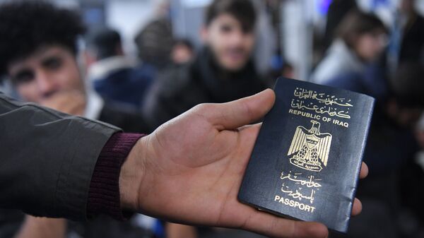 Иракский паспорт в руке одного из беженцев, ожидающих в международном аэропорту Минска вывозных рейсов авиакомпании Iraqi Airways - Sputnik Беларусь