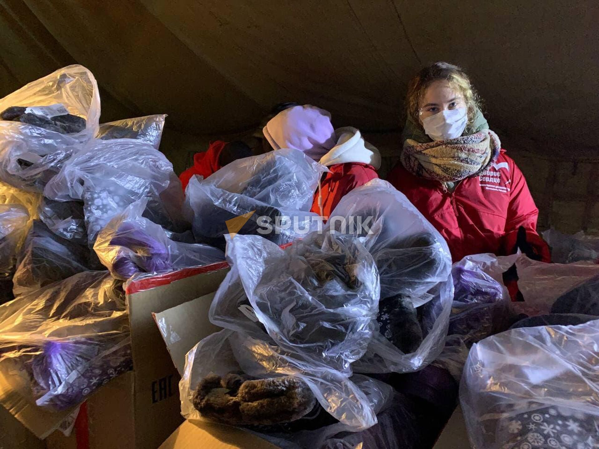 Волонтеры Белорусского общества Красного Креста передали мигрантам почти 900 пар зимней обуви - Sputnik Беларусь, 1920, 27.11.2021